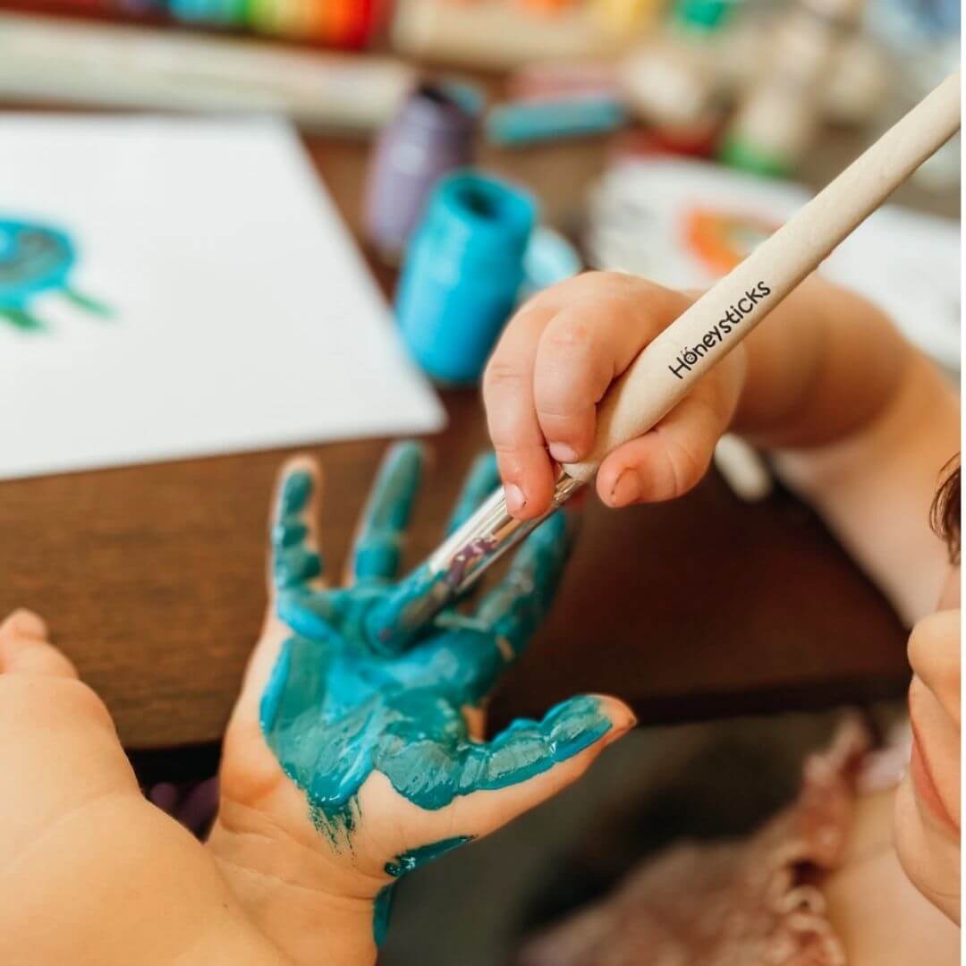 Painting hands with Honeysticks jumbo paint brushes